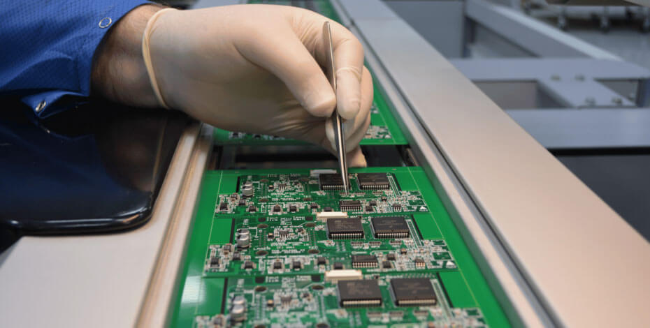 Man wearing glove working on circuit board